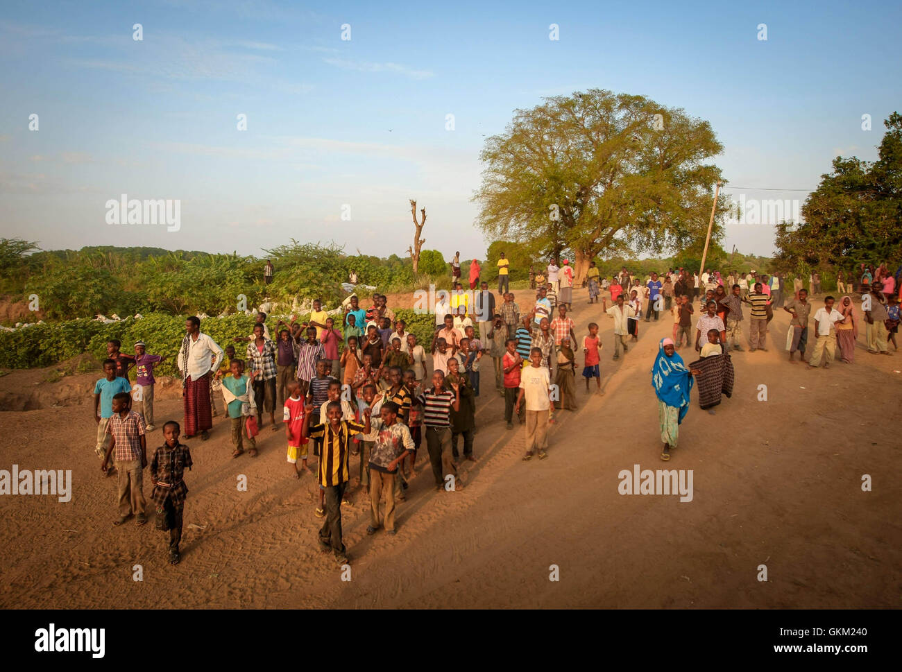 La SOMALIE, Jawahar : Dans un document de cours photographie prise le 10 décembre et publié par l'Union africaine et l'équipe de support d'information des Nations Unies 12 décembre, les civils somaliens et les enfants de la route de l'onde comme une colonne blindée de la Mission de l'Union africaine en Somalie (AMISOM) à travers la ville de Jawahar dans la région du Moyen-Shabelle au nord de la capitale Mogadishu. L'armée nationale somalienne (SNA) force appuyée par la Mission de l'Union africaine en Somalie (AMISOM) a capturé la ville de Jawahar, 90km au nord de Mogadiscio, le 9 décembre de l'Al-Qaeda groupe extrémiste affiliés à Al Chabaab encounterin Banque D'Images