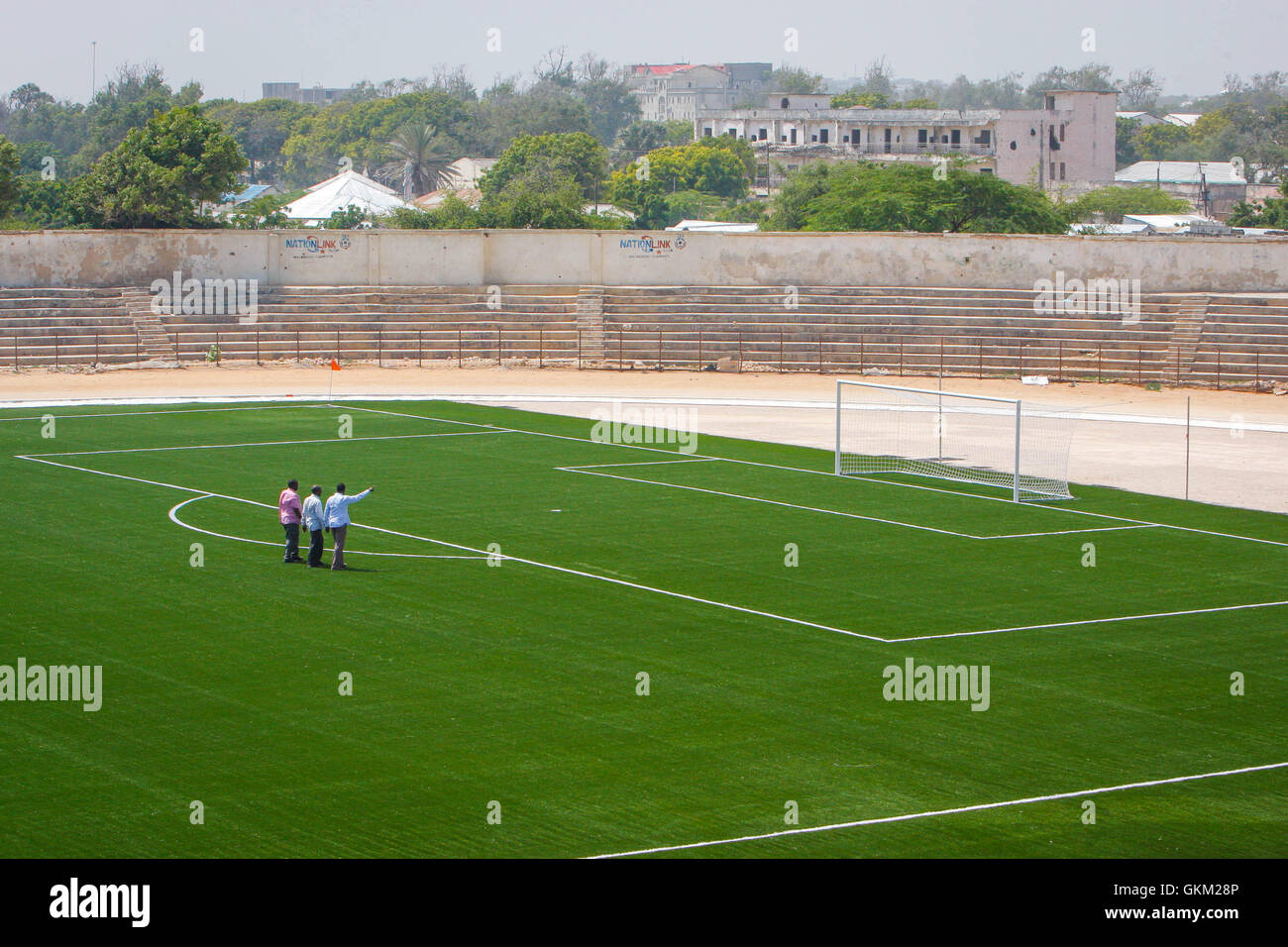 La Somalie, Mogadiscio : une brochure photographie datée du 12 janvier et publié par l'Union africaine et l'équipe de support d'information des Nations Unies 16 janvier, montre les membres de la Fédération de football somaliens (SFF) à pied à travers l'intérieur du stade de football Baanadir Abd-Aziz dans le district de la capitale Mogadishu, qui a récemment été refait surface avec une nouvelle surface de jeu artificielle. Financé par la FIFA, le MFS a eu la capacité de 7 500 stadium re-renvoyé et va bientôt commencer les travaux de réfection de sièges, un parking gratuit et d'autres installations qui sont actuellement en proie à des rappels de la Somalie en proie à la guerre du passé. Banque D'Images