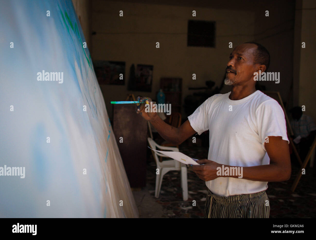 L’artiste somalien Mohamed Mudey commence à peindre une murale au Centre de recherche et de dialogue (CRD) de Mogadiscio le 15 janvier. La murale représente la résurgence de l’art et de la culture somaliens après la libération de la ville du contrôle d’Al-Shabaab. Banque D'Images