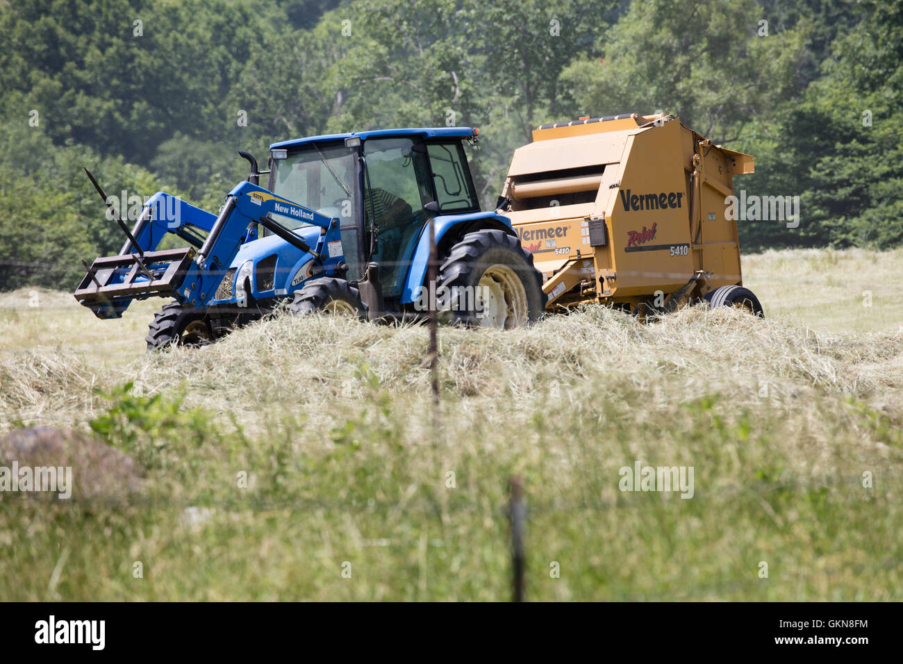 Le tracteur tirant à balles de foin rondes un Banque D'Images