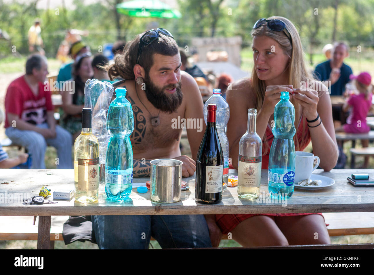 Couple assis à table bouteilles de différentes boissons Hot Summer Garden Party homme femme Summer Relax Outside People Relax Leisure Lifestyle Summerly Banque D'Images