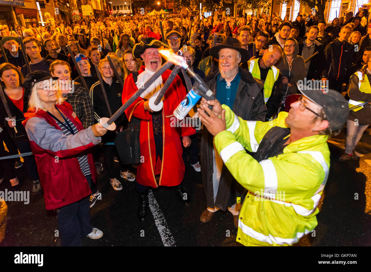 Bridport, Dorset, UK. Août 21, 2016. Adjoint au maire Anne Rickard, crieur public John Collingwood et David Rickard sont les premiers à avoir leurs torches allumées d'environ 2 000 personnes qui ont pris part à l'Assemblée Bridport Carnival défilé aux flambeaux qui part de Bridport Town Hall et va à un mille et demi à West Bay Beach. Crédit photo : Graham Hunt/Alamy Live News Banque D'Images