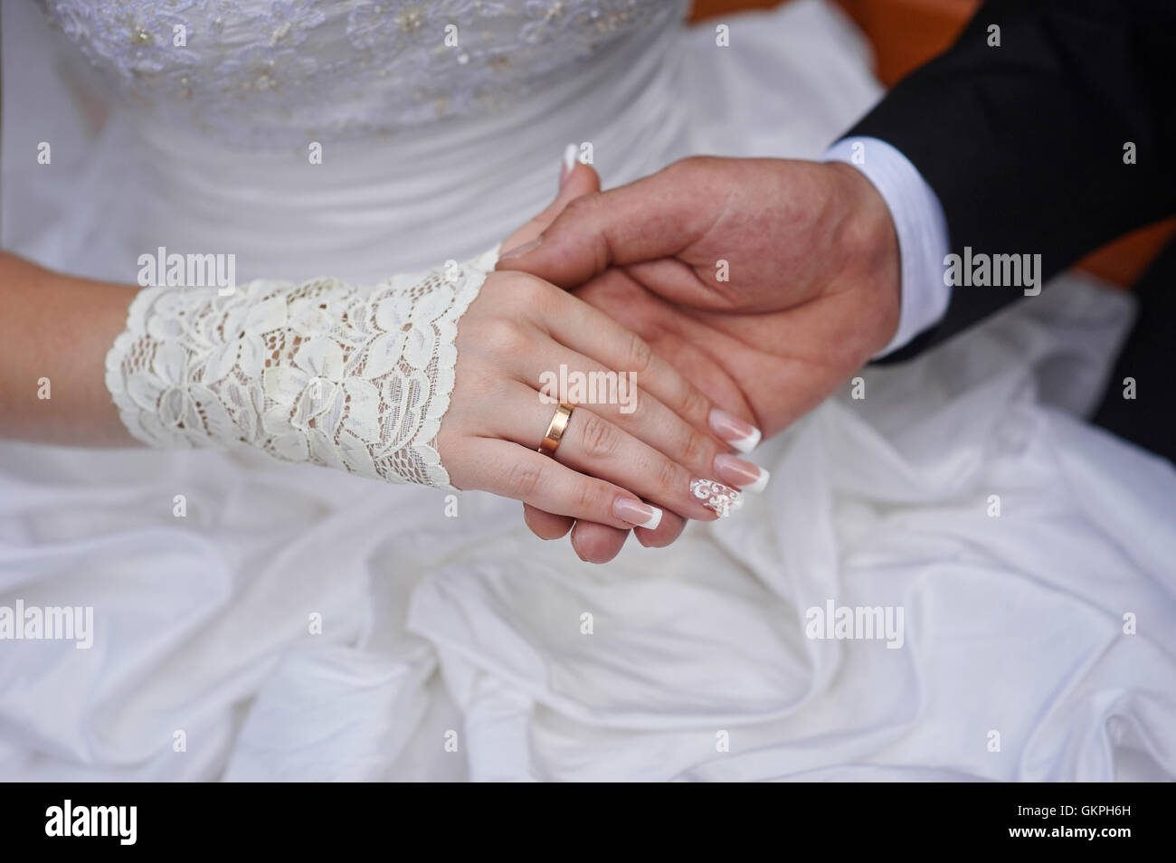 Groom tient sa main de la mariée avec anneau de mariage Banque D'Images
