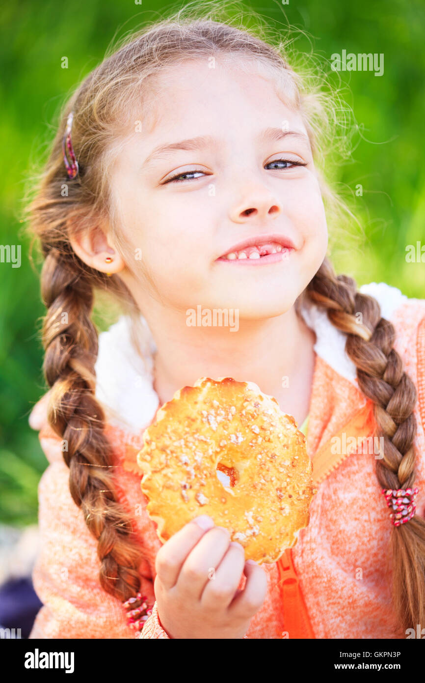 Douce jeune fille tenant un toth tenant une pomme dans sa main sur la nature Banque D'Images