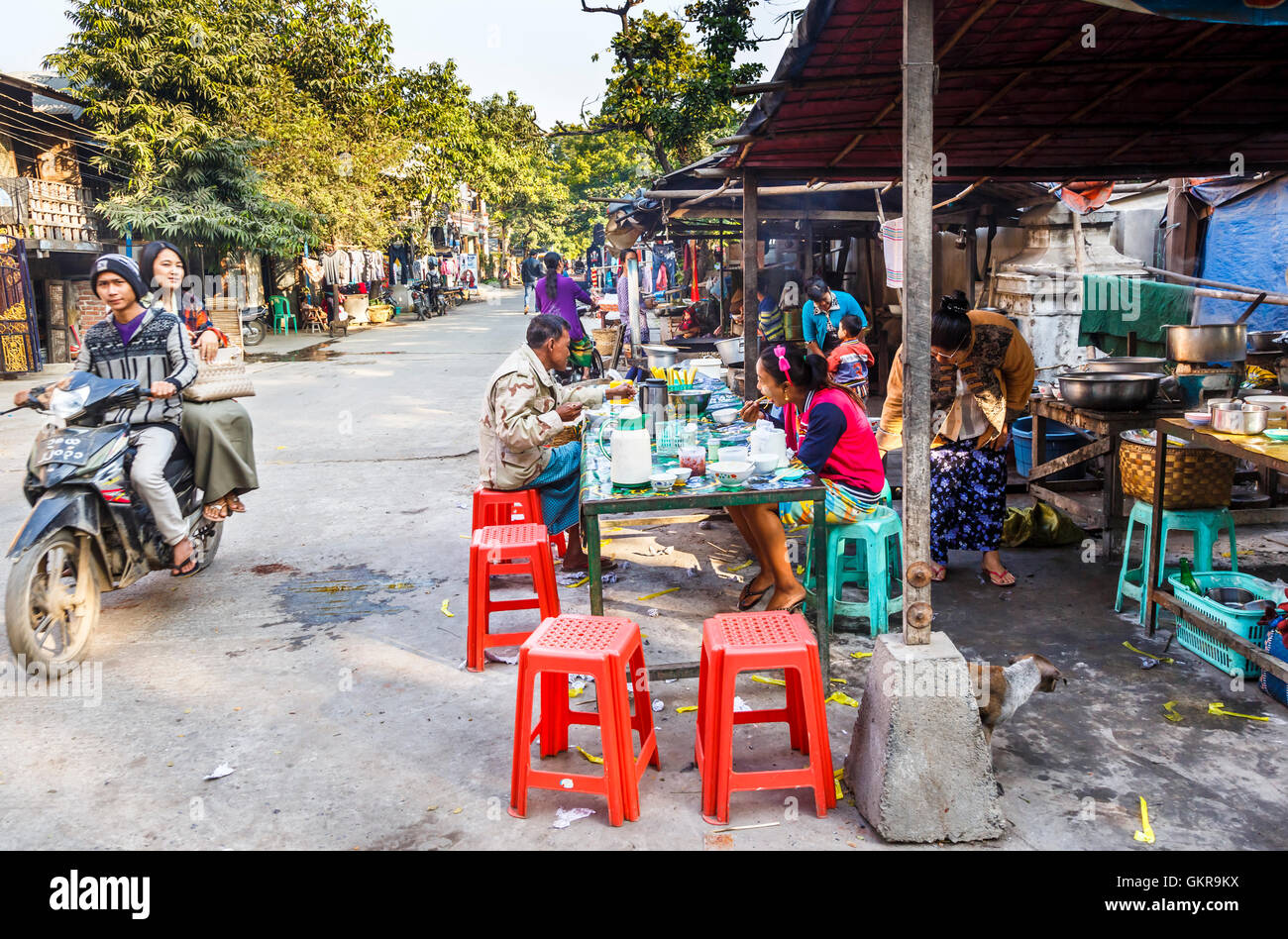 Scène de rue typique matin au marché de Jade, Mandalay, Myanmar (Birmanie), la population locale de prendre le petit déjeuner dans des cafés Banque D'Images