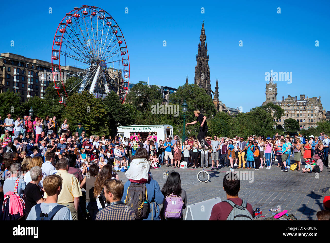 Un artiste de rue divertit la foule à la butte pendant le Festival Fringe d'avec grande roue, Scott Monument Banque D'Images