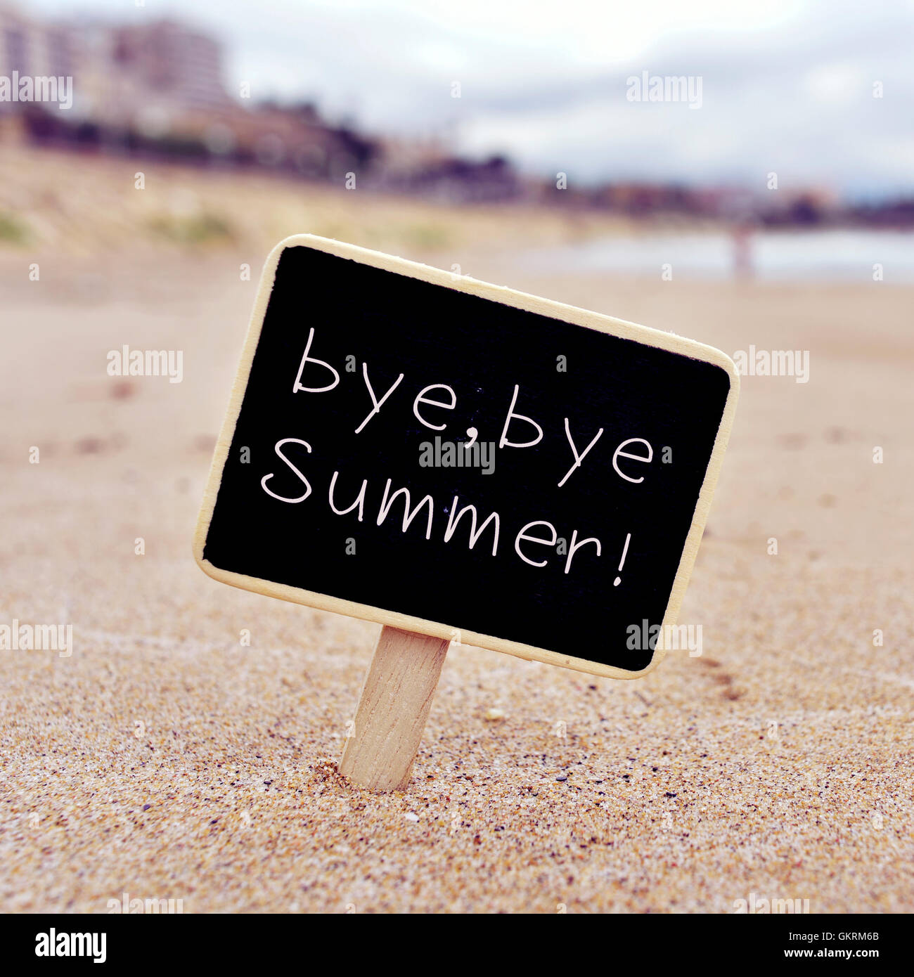 Libre d'une pancarte noire avec le texte bye, bye l'été écrit en C, sur le sable d'une plage Banque D'Images