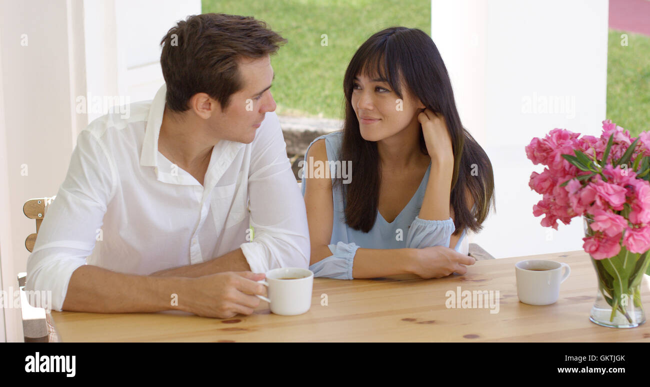 Happy young couple mixte sitting at table Banque D'Images