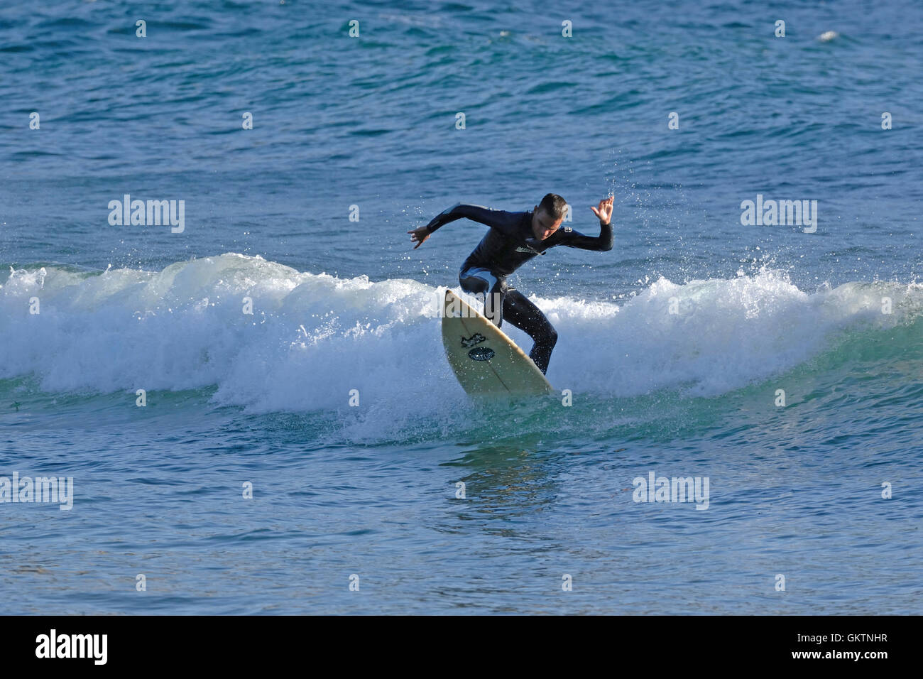 Surfer une vague sur la plage de Santa Caterina di Pittinuri, Sardina island de l'Italie Banque D'Images