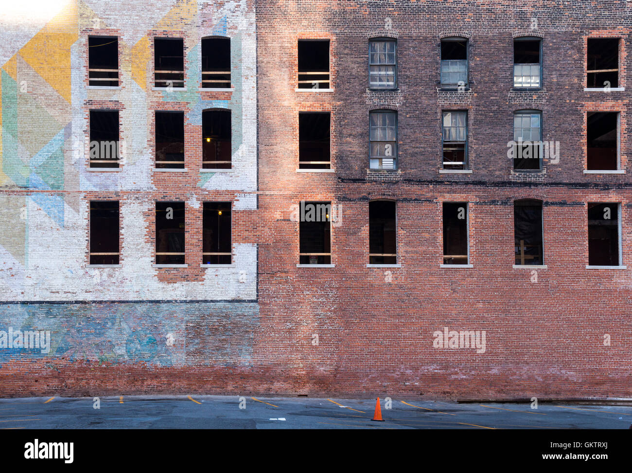 Vieux bâtiment abandonné dans le centre-ville de Detroit. Façade de briques, en partie avec une peinture colorée. Fenêtres brisées. Banque D'Images