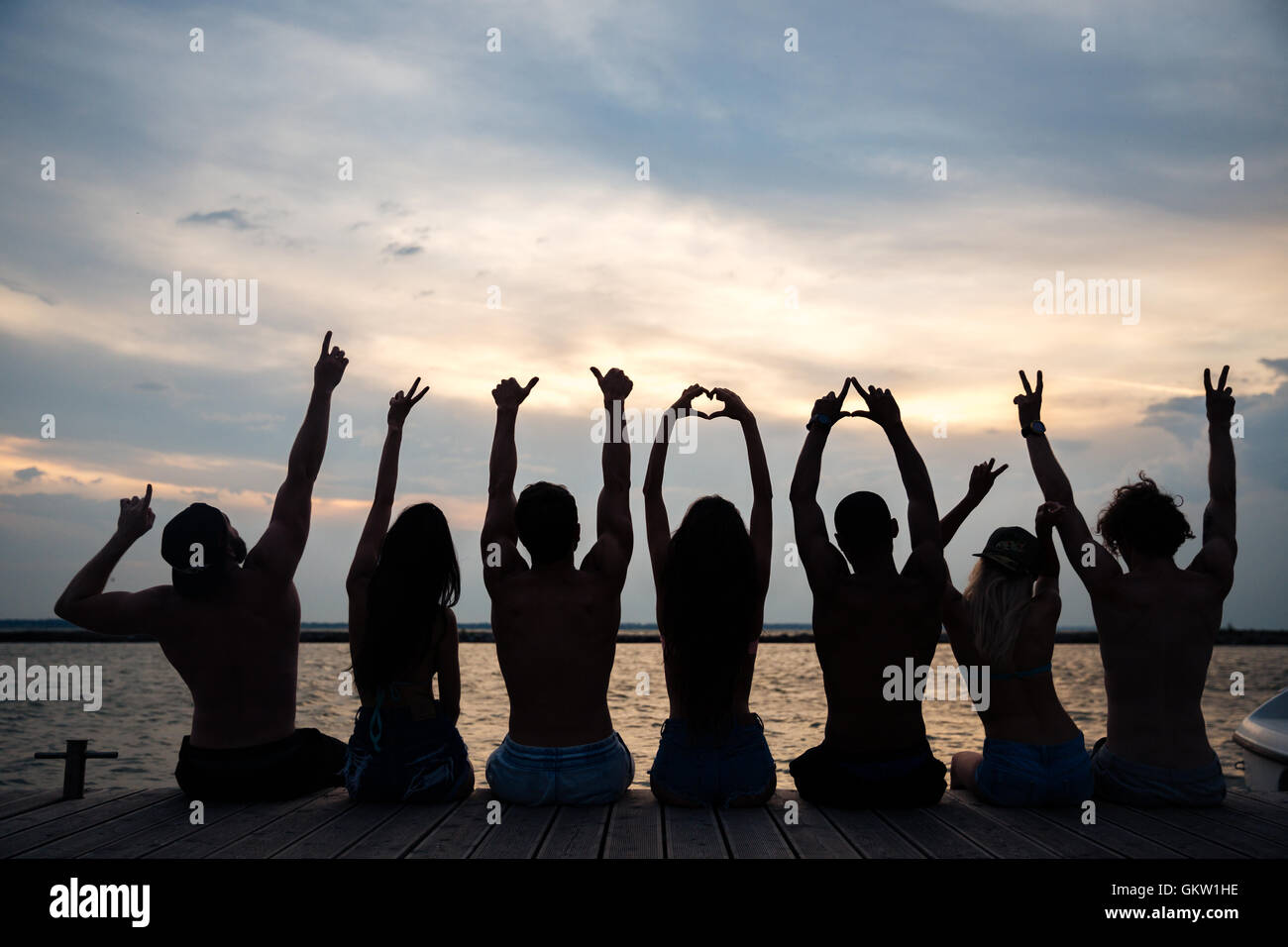 Femme assise devant le coucher de soleil Banque de photographies et d