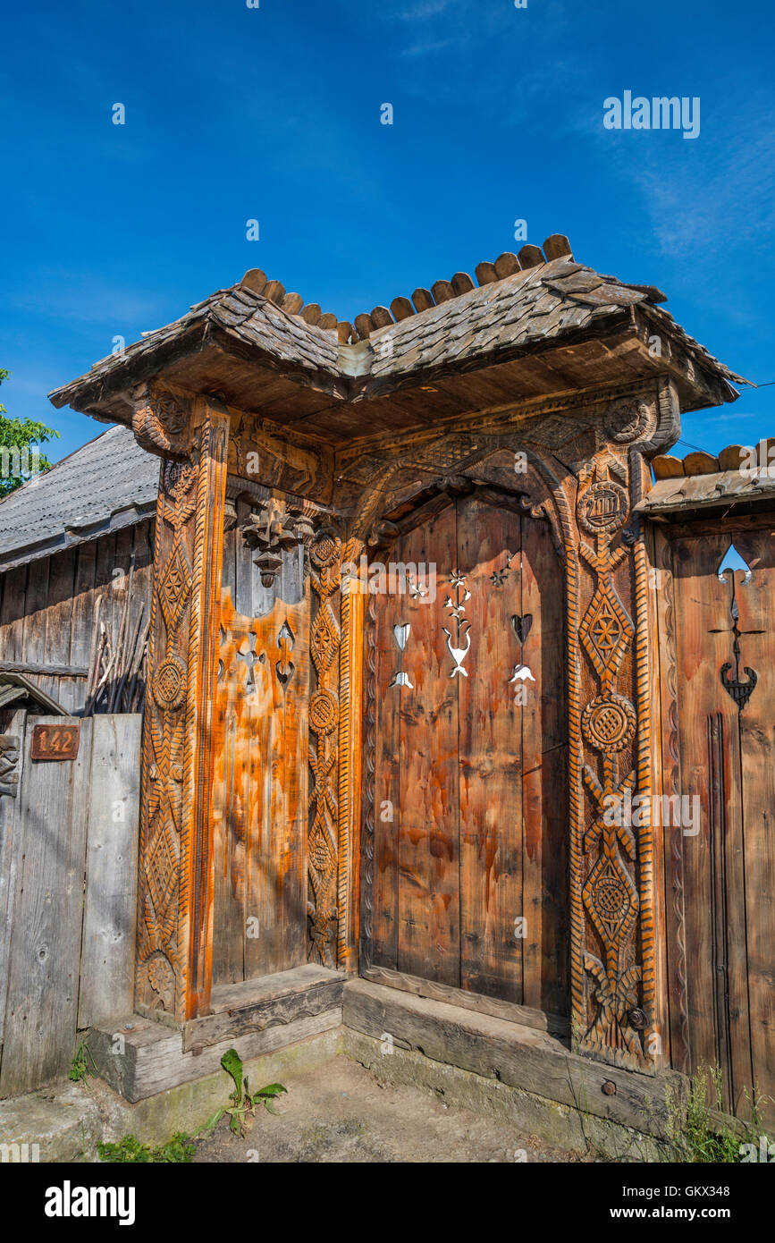Porte en bois sculpté à ferme en village de Mara, région du Maramures, Roumanie Banque D'Images