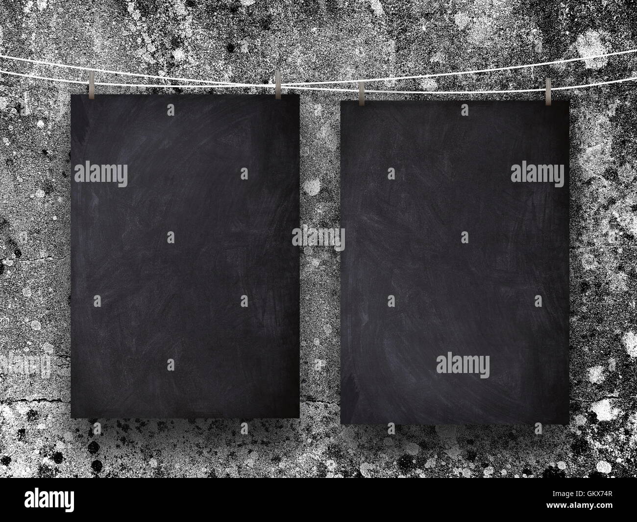 Close-up of two blank blackboard pendu par châssis gris chevilles contre mur de béton rugueux contexte Banque D'Images