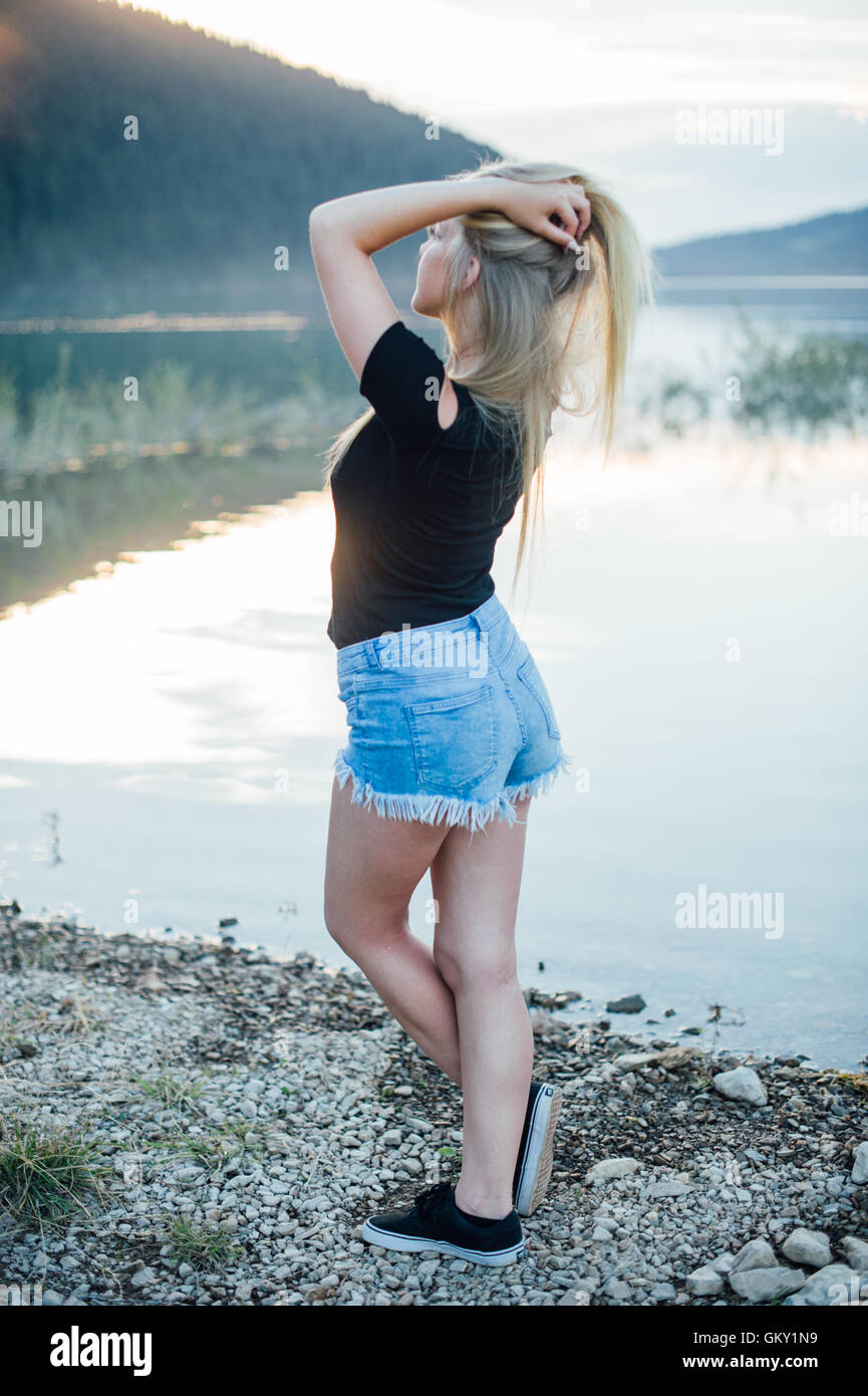 Portraits d'une jeune fille blonde en face d'un lac. Banque D'Images
