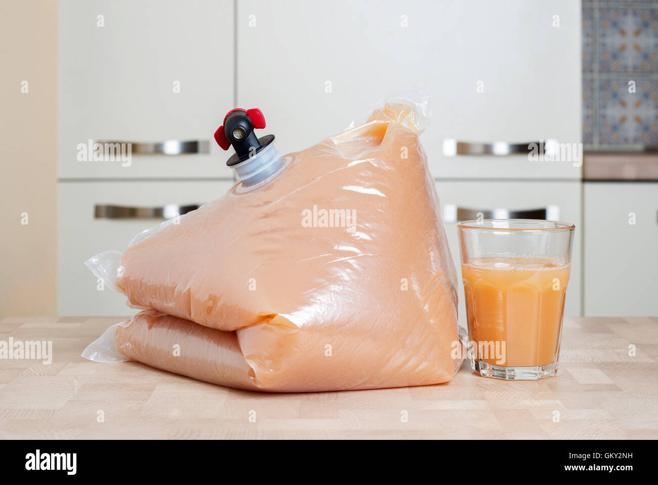 Sac en plastique et verre de jus de pomme Banque D'Images