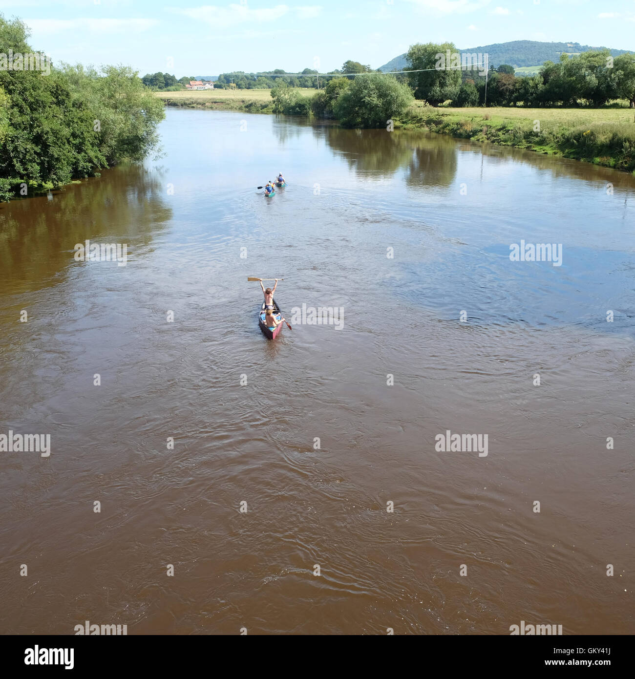 Whitney On Wye, Herefordshire, Royaume-Uni, août 2016. Une paire de canots en aval de la palette sur la rivière Wye après être passé sous le pont à péage Whitney en direction de Hereford dans le soleil d'été. La rivière Wye est un endroit populaire pour le canotage et location de canoë. Banque D'Images