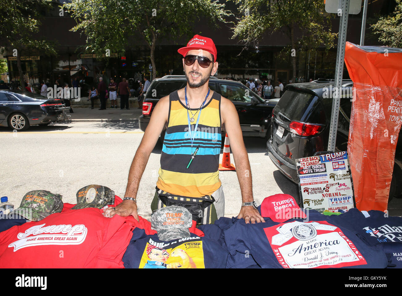 Austin, Texas, États-Unis. Août 23, 2016. Tommy, Dastamanis de Bradenton, en Floride, a été candidat à la présidence républicaine suivantes Donald J. Trump de campagne électorale à travers le pays pour vendre des marchandises aux partisans. Dastamanis met en place sa table à l'ombre d'une ligne d'arbres le long de la Deuxième Avenue dans le centre-ville d'Austin en tant que partisans d'Atout attendre d'admission à la Moody Théâtre pour un service d'enregistrement d'une réunion publique organisée par Fox News et commentateur politique Sean Hannity. Crédit : Scott W. Coleman/ZUMA/Alamy Fil Live News Banque D'Images