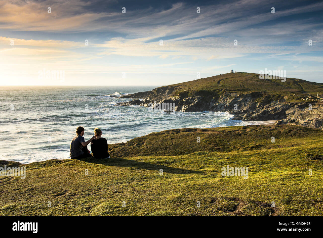 Les vacanciers profitant de la lumière du soleil du soir, assis sur la Pointe à Newquay, Cornwall. Banque D'Images