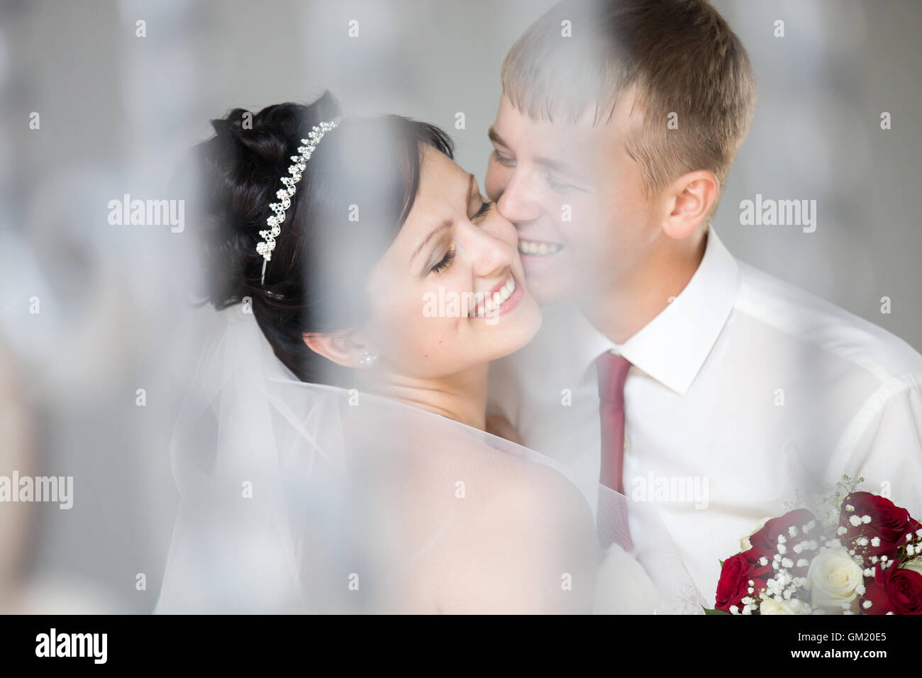 Jeune couple de mariage joyeux rire et câlins à l'extérieur. Beautiful happy bride hugging et baisers avec beau Banque D'Images