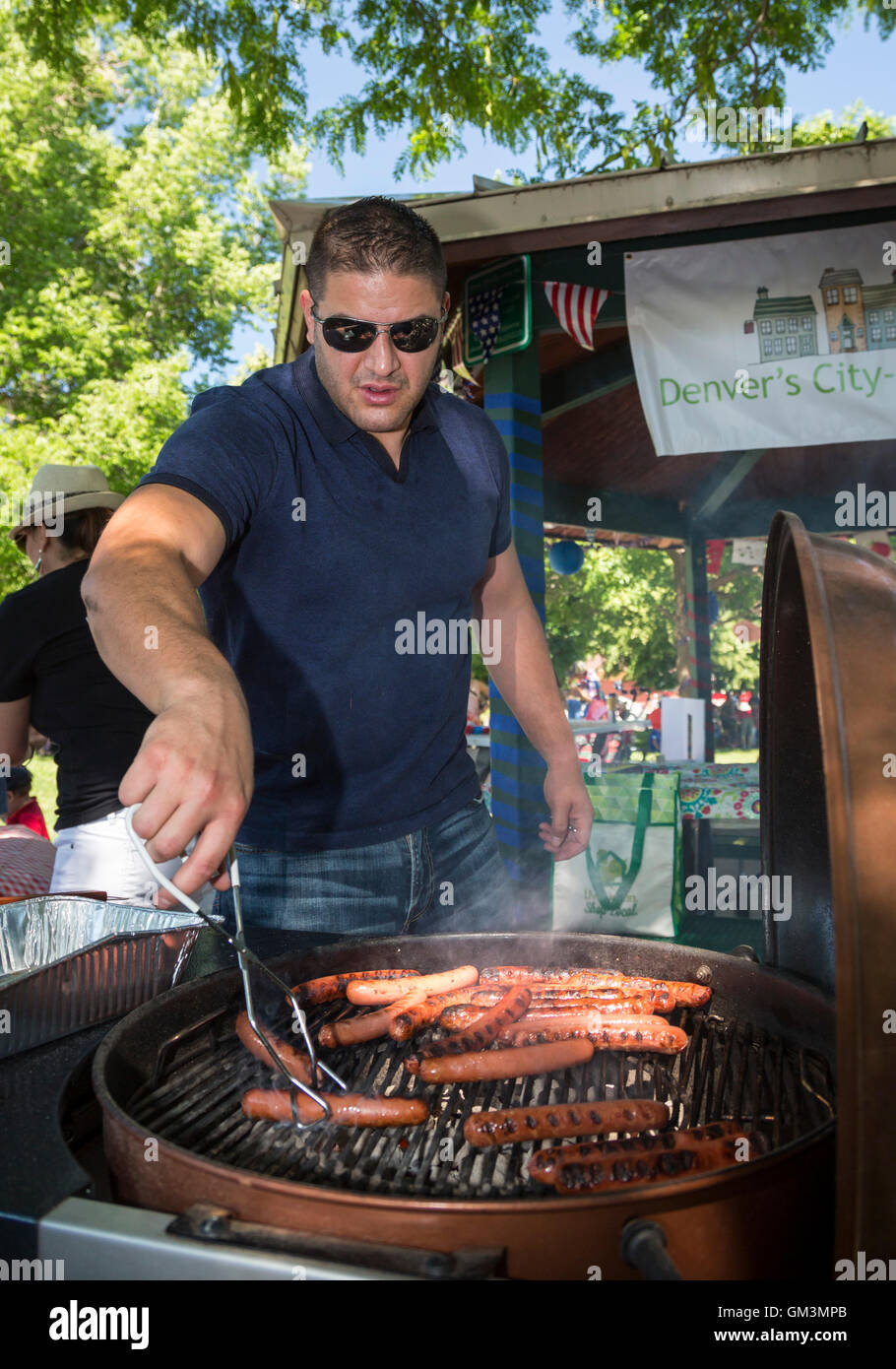 Aspen, Colorado - un homme des barbecues des hot dogs à un pique-nique et défilé le 4 juillet dans la banlieue de Denver. Banque D'Images