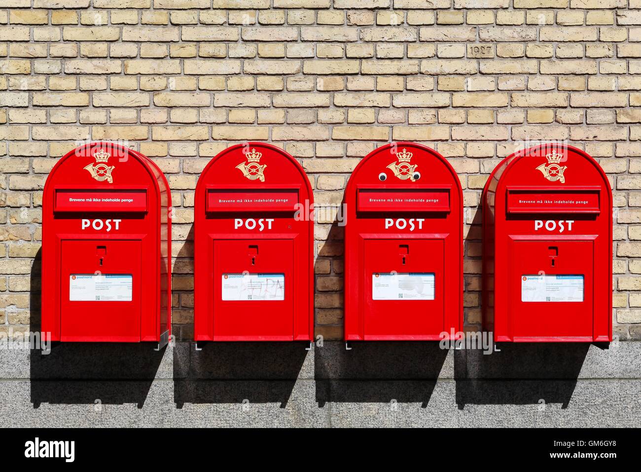 Les boîtes aux lettres danois rouge sur un mur Banque D'Images
