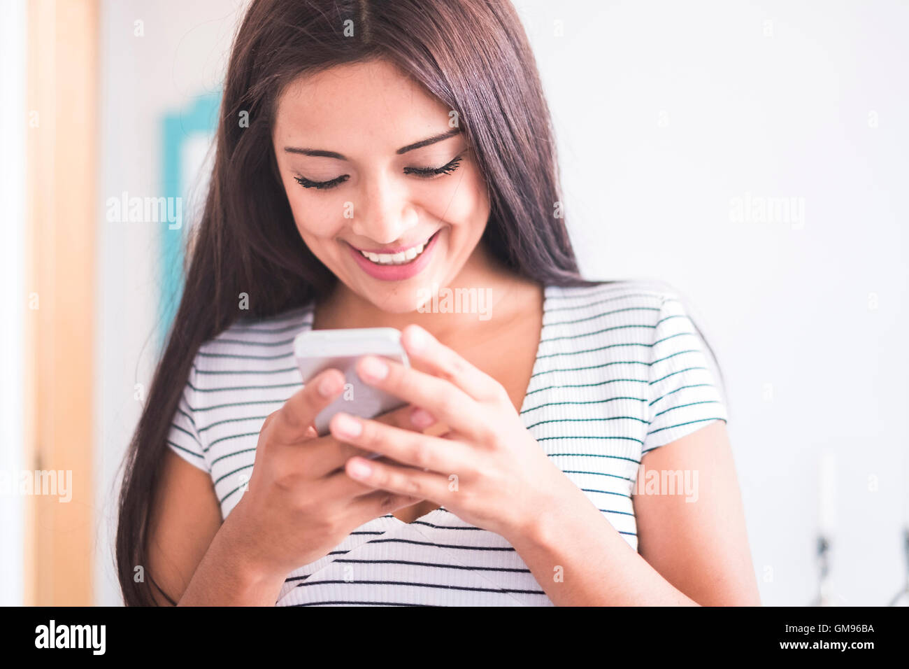 Smiling teenage girl looking at cell phone Banque D'Images