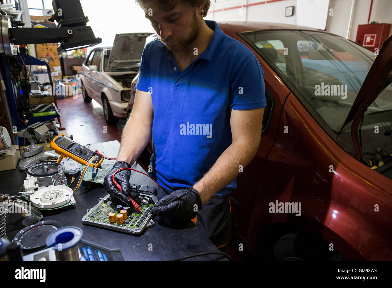 Une fixation mécanique de pièces de voiture électronique dans son atelier Banque D'Images