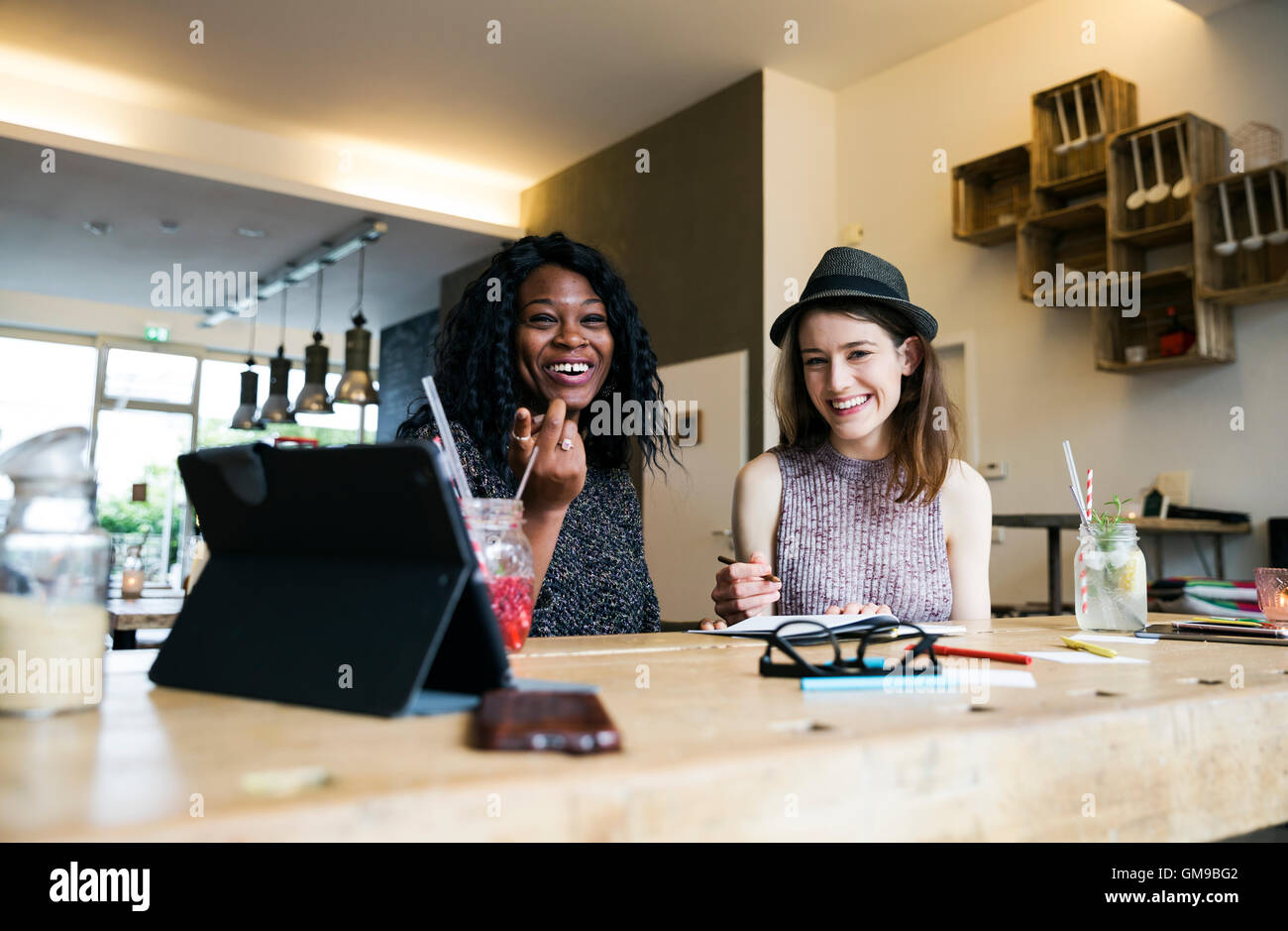 Deux amis using digital tablet in cafe Banque D'Images