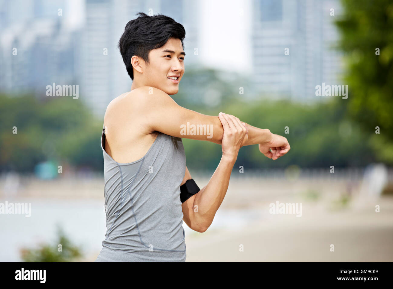 Young Asian man réchauffe en étirant les bras avant l'exercice. Banque D'Images