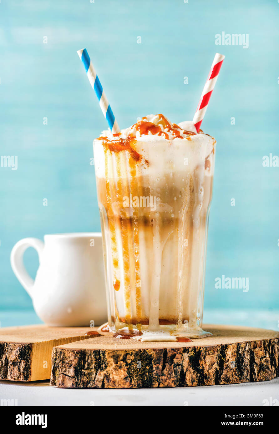 Latte macchiato avec crème fouettée et coulis de caramel dans grand verre  sur planche de bois peinte en bleu sur fond de mur Photo Stock - Alamy