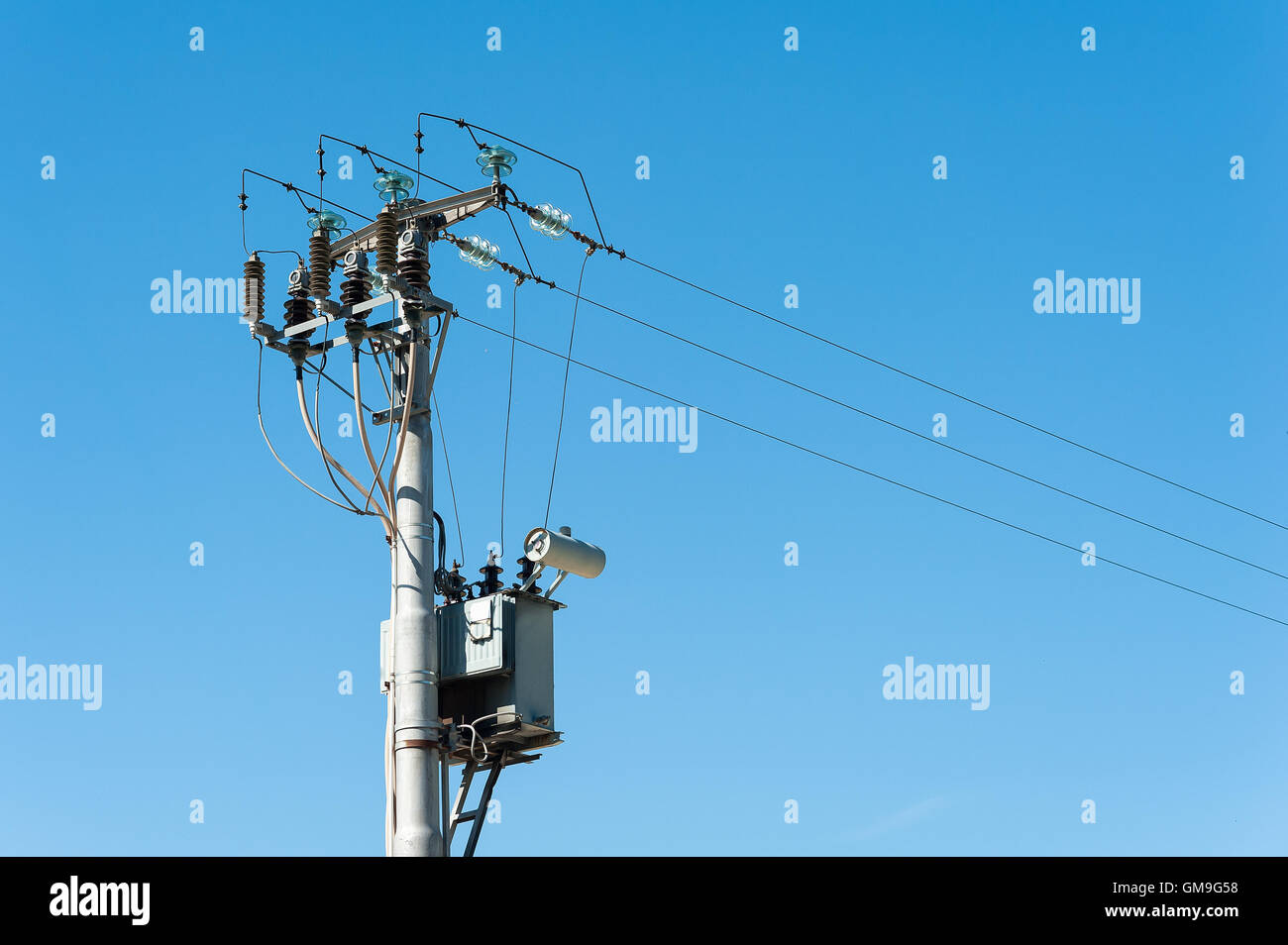 Transformateur électrique de pylône électrique contre le ciel bleu Banque D'Images