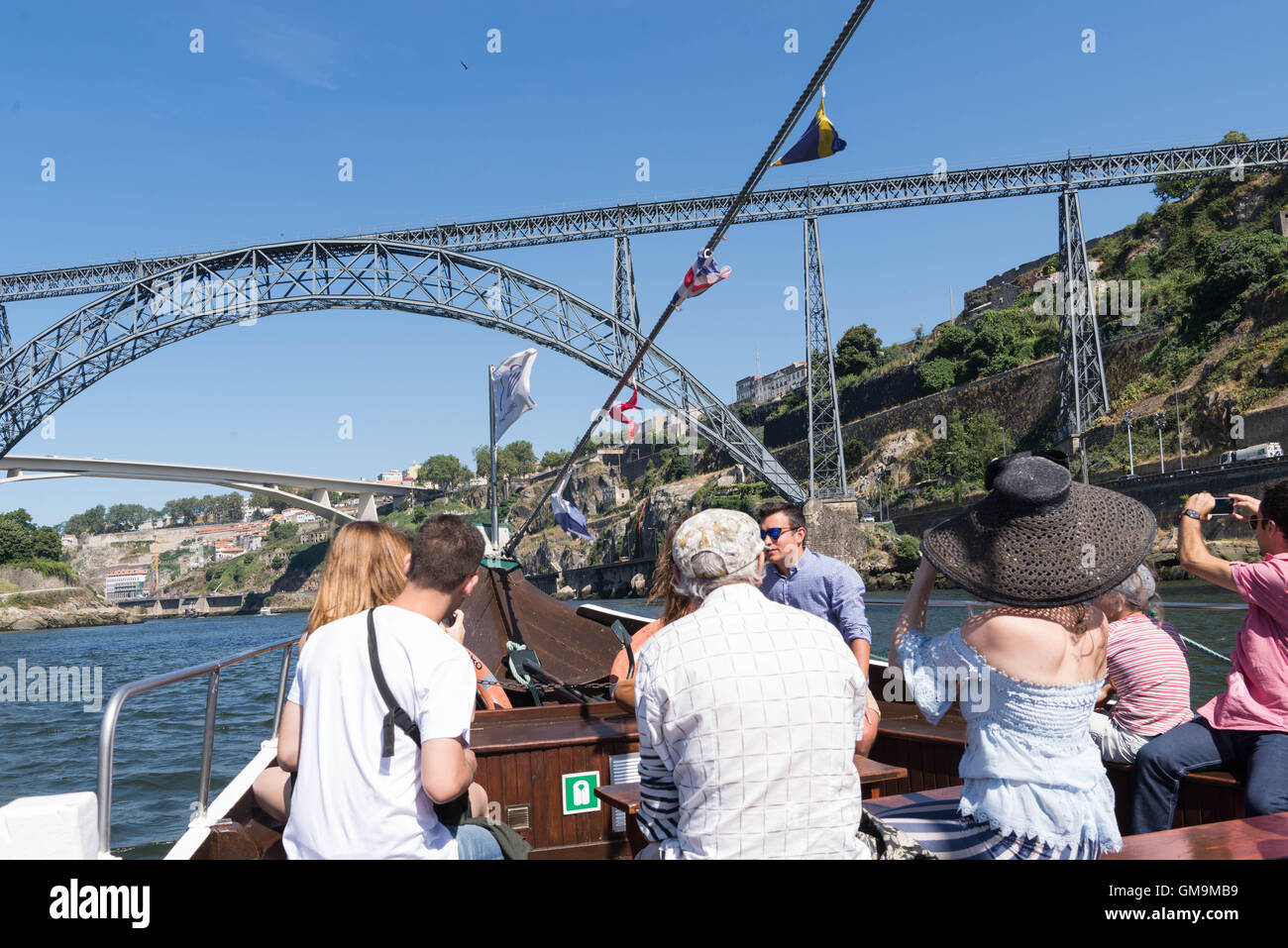 Touristes sur une croisière fluviale de six ponts à l'approche de la Puente María Pía, Porto, Portugal. Banque D'Images