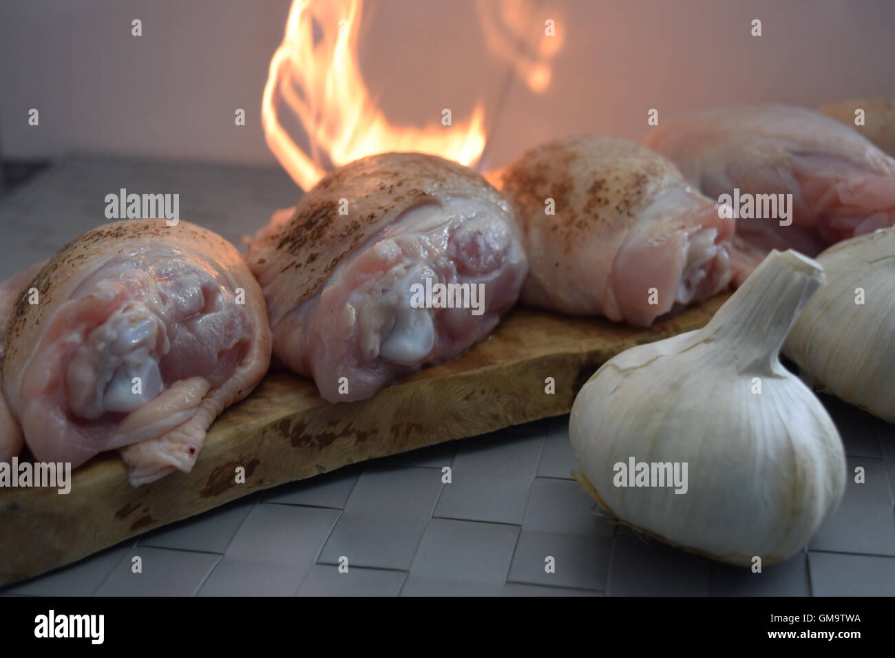 Cuisses de poulet avec l'ail sur feu Banque D'Images