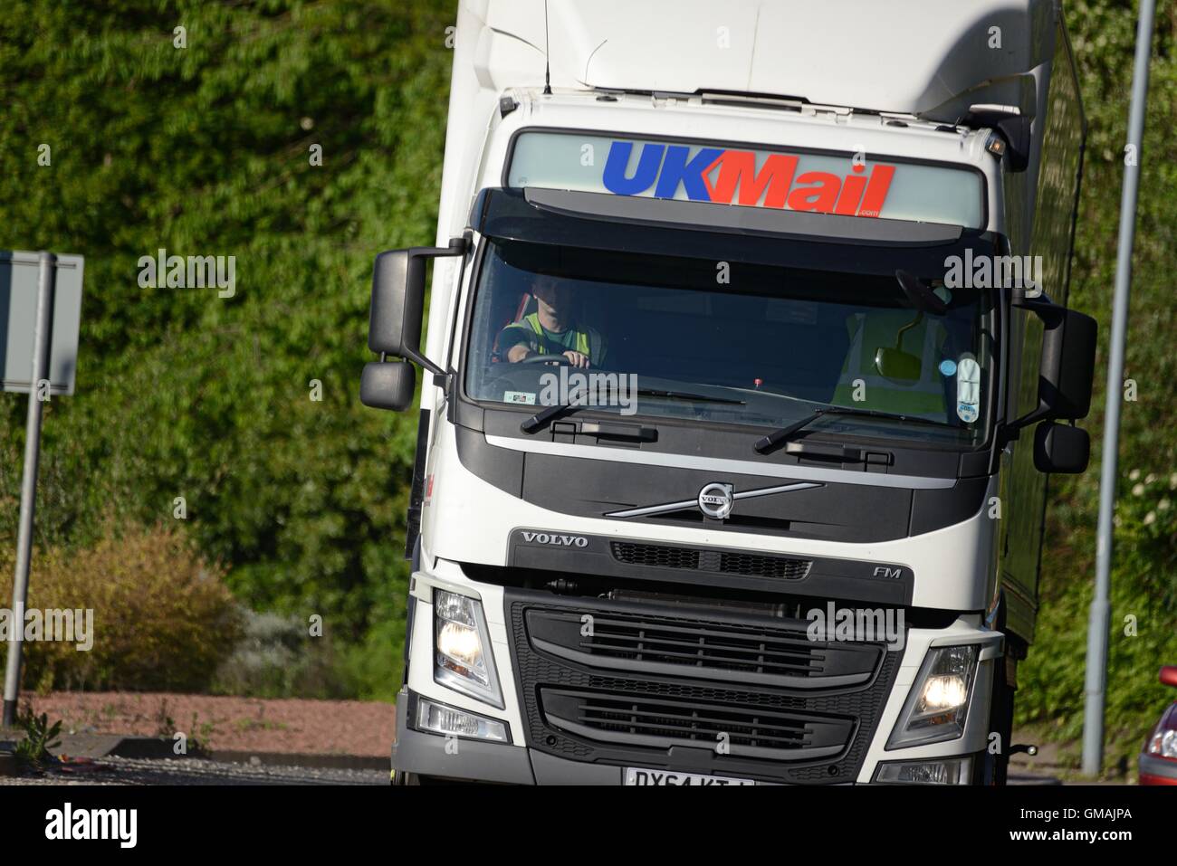 Sur l'avant-coup de UK Mail articulé camion Volvo FH mail prendre un petit rond-point dans un environnement de banlieue Banque D'Images