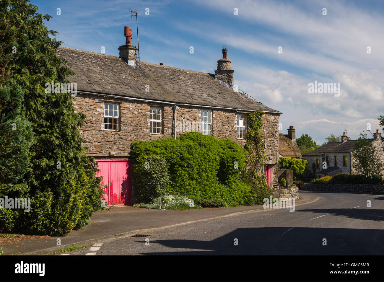 Country lane se plie tour traditionnelle, construite en pierre, Yorkshire Dales cottages - Austwick village, North Yorkshire, Angleterre. Banque D'Images
