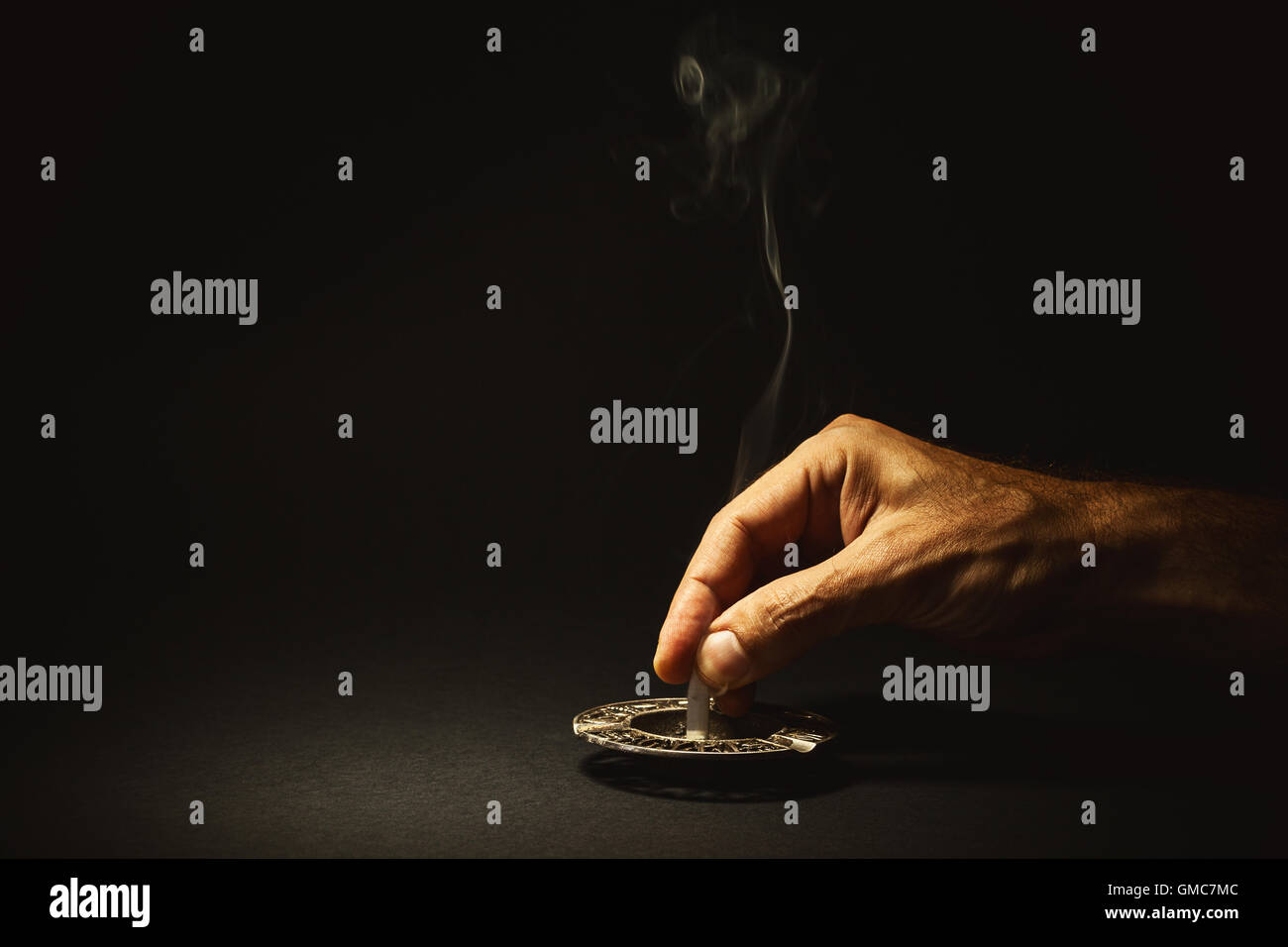 Composition conceptuelle à propos de cesser de fumer, la main de l'homme s'éteint un cigare. Banque D'Images