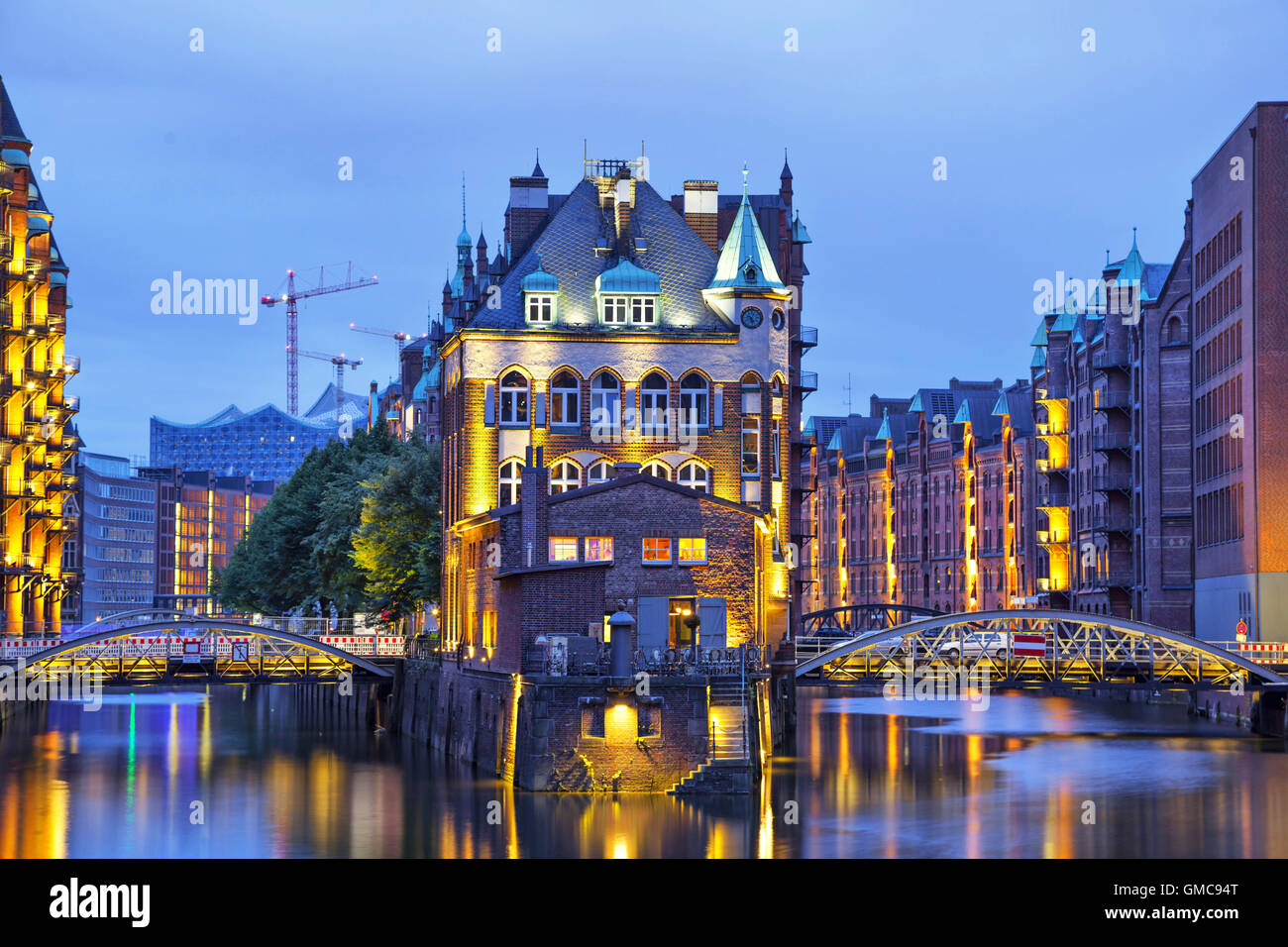 Chambre et deux jeunes mariées éclairés en soirée dans le vieux quartier des entrepôts (Speicherstadt), Hambourg, Allemagne Banque D'Images