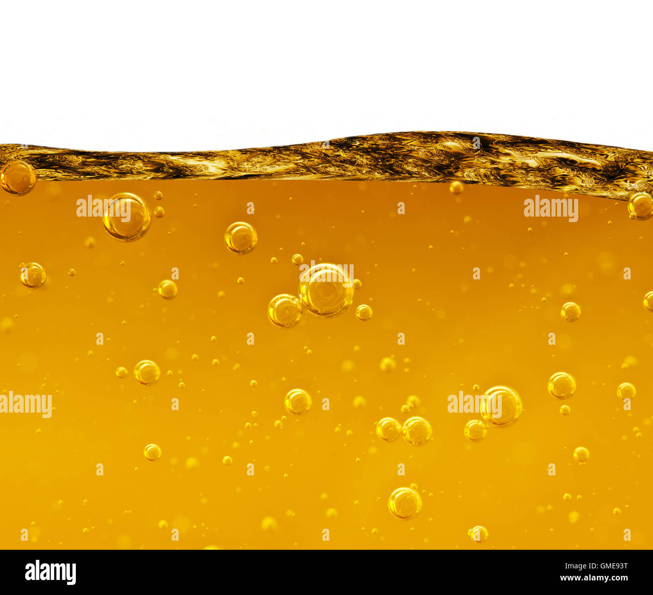 Vague d'un liquide jaune avec des bulles d'air sur un fond blanc Banque D'Images