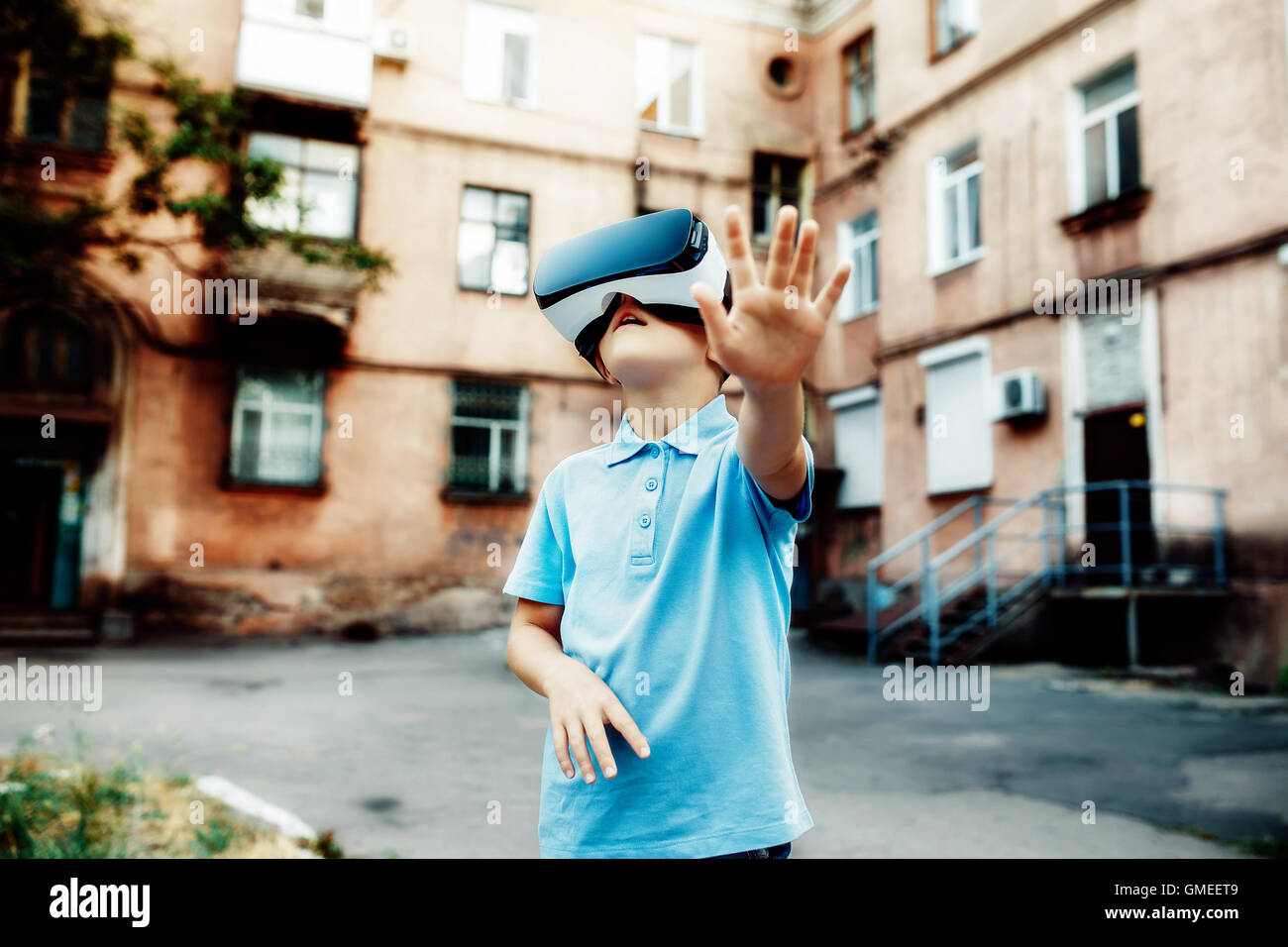 Petit garçon fasciné en utilisant des lunettes de réalité virtuelle VR en plein air. Banque D'Images