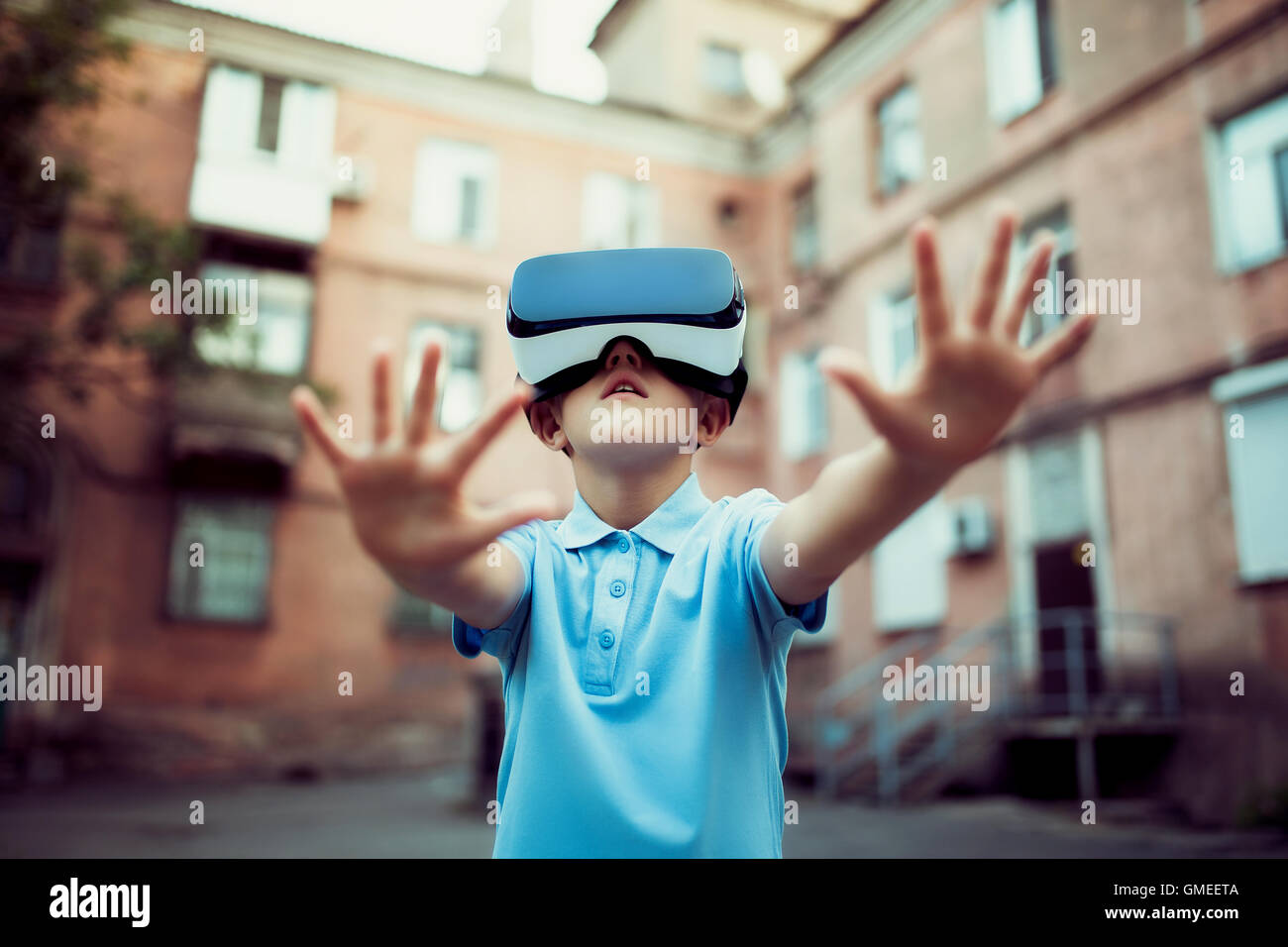 Petit garçon fasciné en utilisant des lunettes de réalité virtuelle VR en plein air. Banque D'Images