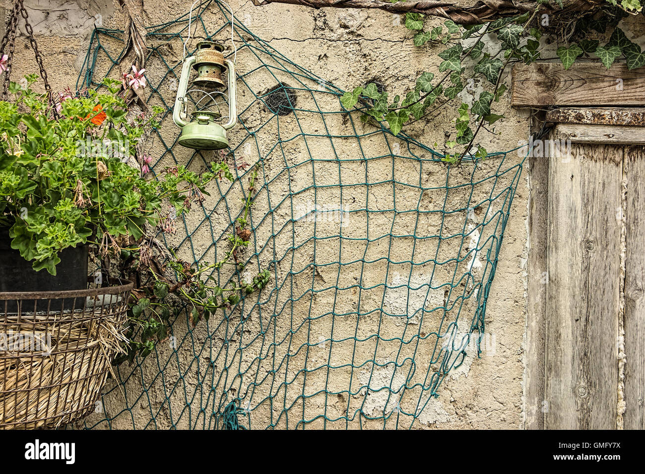 Fond rustique, ancienne ferme avec un filet, vieille porte en bois, et lampe vintage Banque D'Images