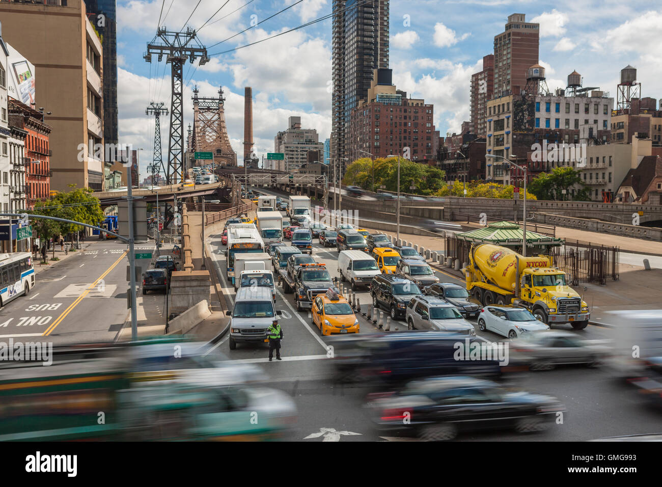 Le trafic entrant dans Manhattan de reines sur le Queensboro Bridge attend pour traverser le trafic sur la 2e Avenue à New York. Banque D'Images
