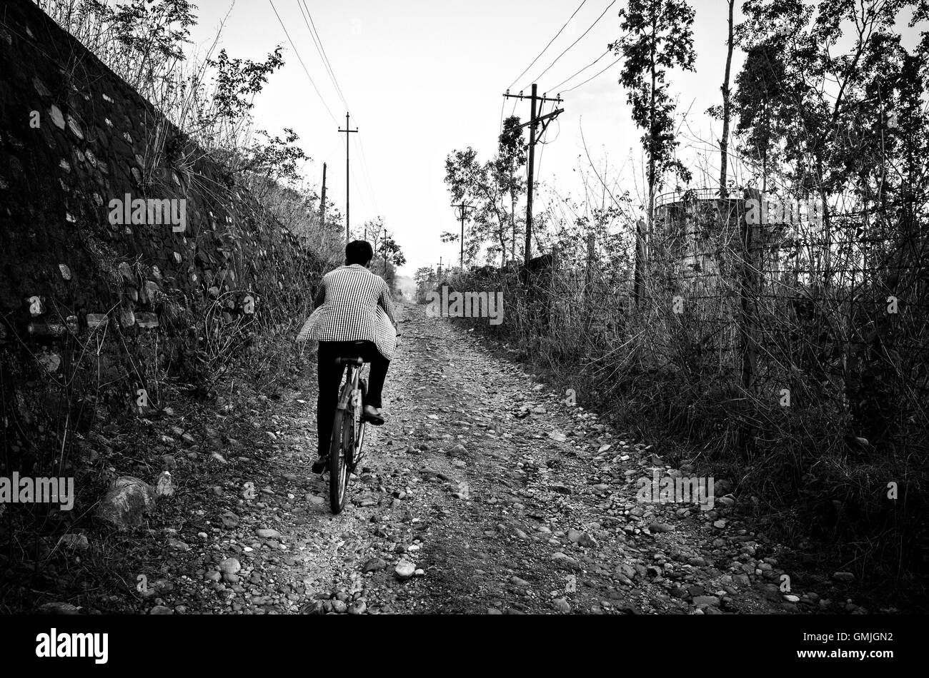 Photo en noir et blanc d'un homme à vélo sur une voie Banque D'Images