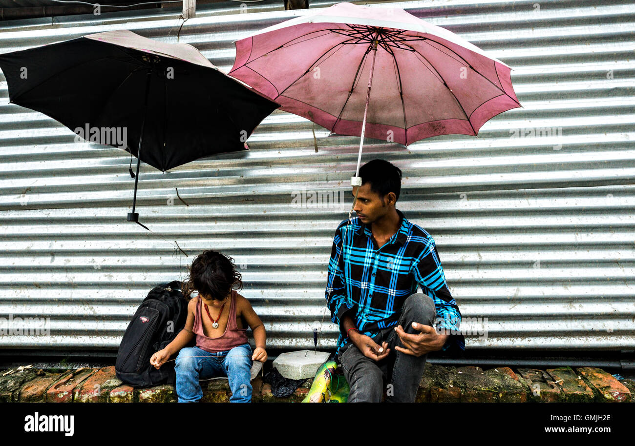 Deux frères en attente de parapluie réparations client dans Kathmandu Banque D'Images