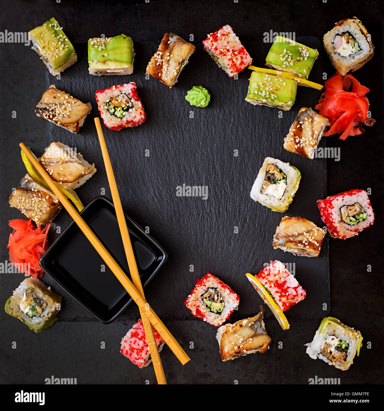 La cuisine japonaise traditionnelle - rouleaux de sushi, et la sauce sur un fond noir. Vue d'en haut Banque D'Images