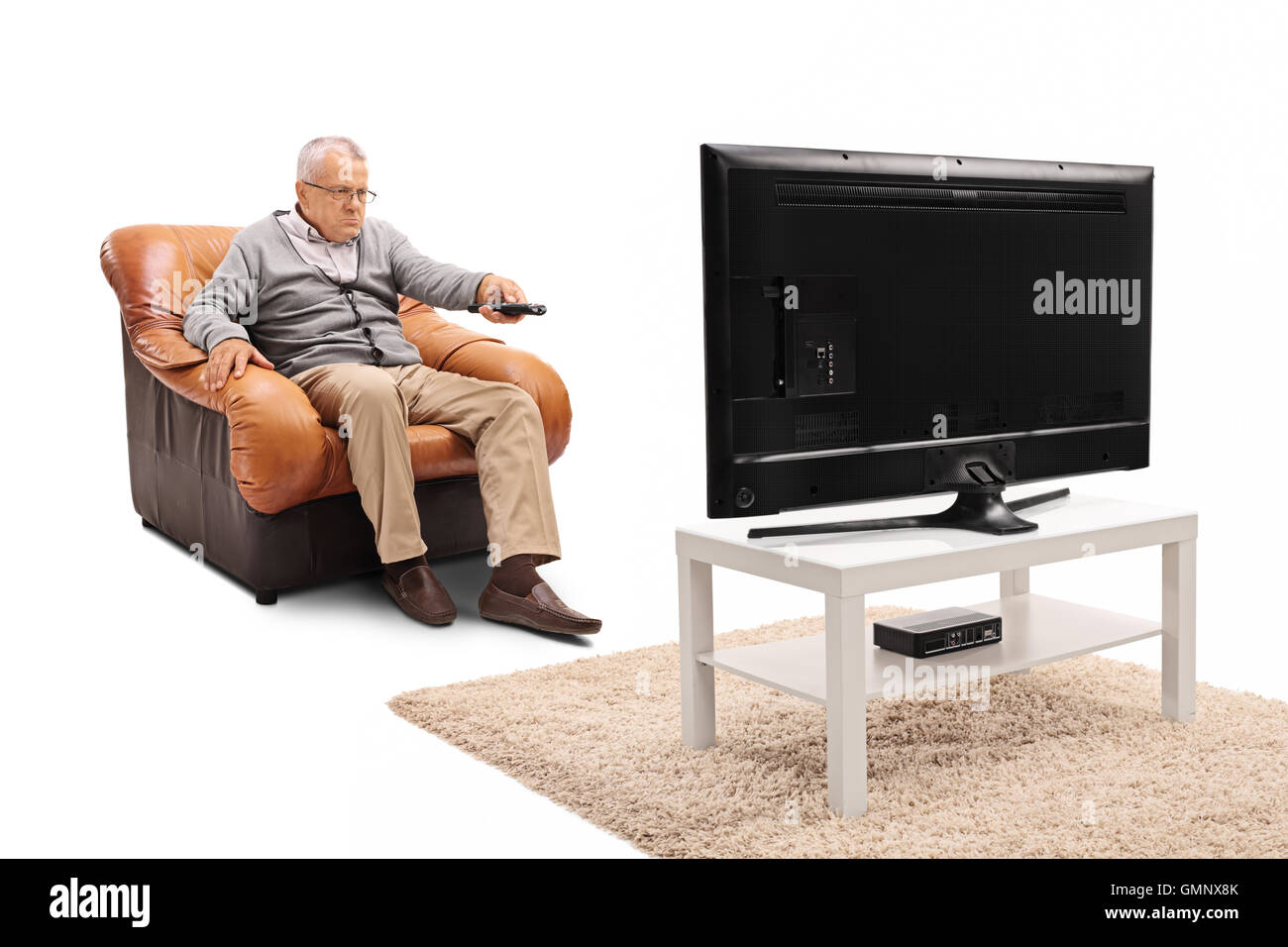 Vieil homme frustré de regarder la télévision et d'un changement de chaîne isolé sur fond blanc Banque D'Images
