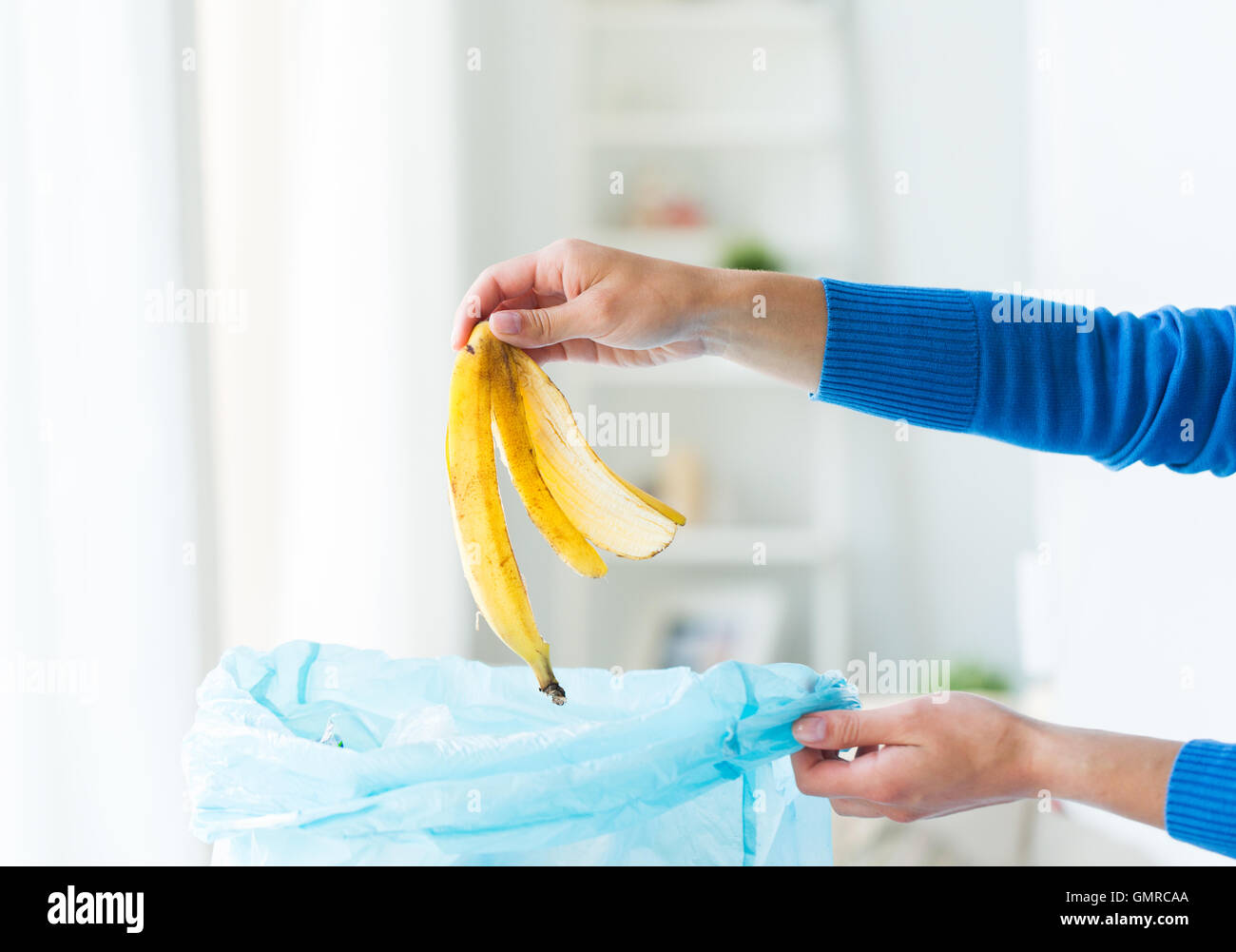 Close up of hand putting déchets alimentaires pour sac poubelle Banque D'Images