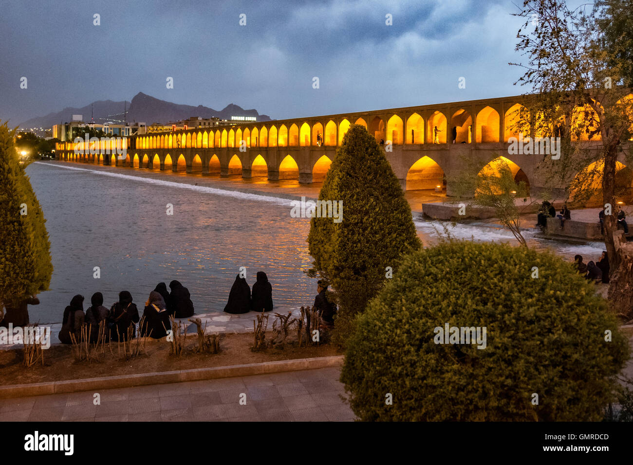Les femmes portant tchador sur les rives de la rivière Zayandeh. Allāhverdi Khan populairement connu sous le nom de pont Si-O-seh pol "Le pont de trente-trois travées" est l'un des 11 ponts d'Isfahan, Iran et le plus long pont sur la rivière Zayandeh avec la longueur totale de 297,76 mètres (976,9 pieds). Il est hautement classé comme étant l'un des exemples les plus célèbres de la conception de ponts safavides. Banque D'Images