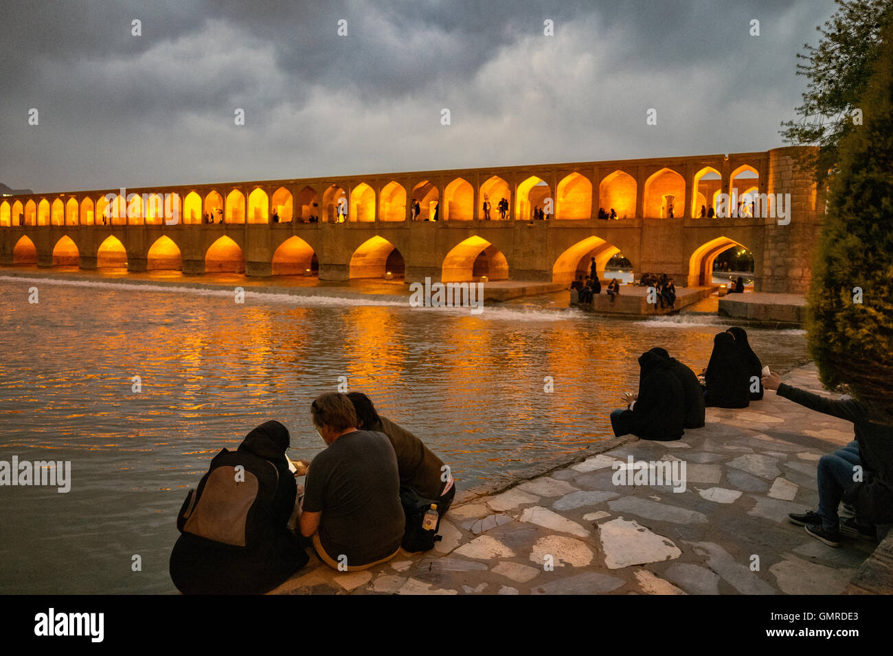 Les femmes portant le hijab et l'utilisation de téléphones cellulaires à l'Allāhverdi Khan populairement connu sous le nom de pont Si-O-seh pol "Le pont de trente-trois travées", l'un des 11 ponts d'Isfahan, Iran et le plus long pont sur la rivière Zayandeh avec la longueur totale de 297,76 mètres (976,9 pieds). Il est hautement classé comme étant l'un des exemples les plus célèbres de la conception de ponts safavides. Banque D'Images