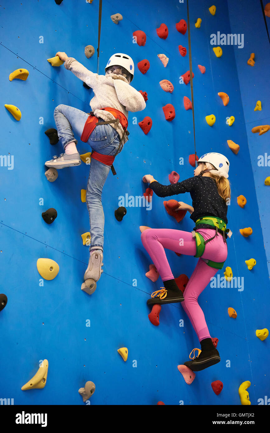 Deux jeunes filles au parc d''Escalade sur mur bleu Banque D'Images